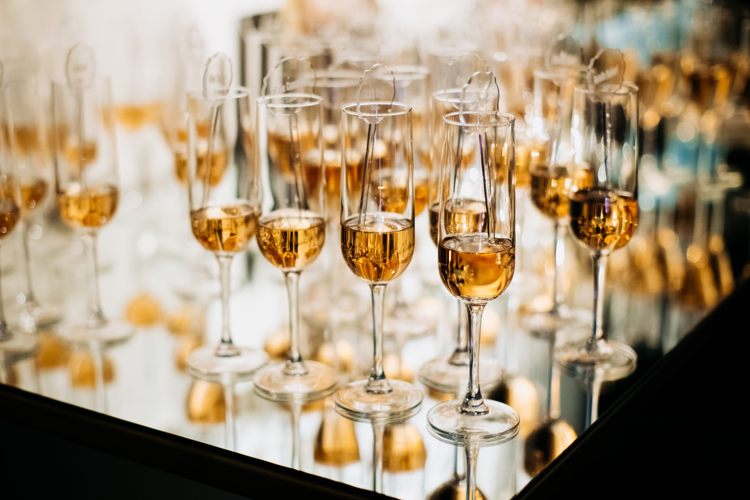Champaigne glasees full of alcohol drinks on the tray with mirr